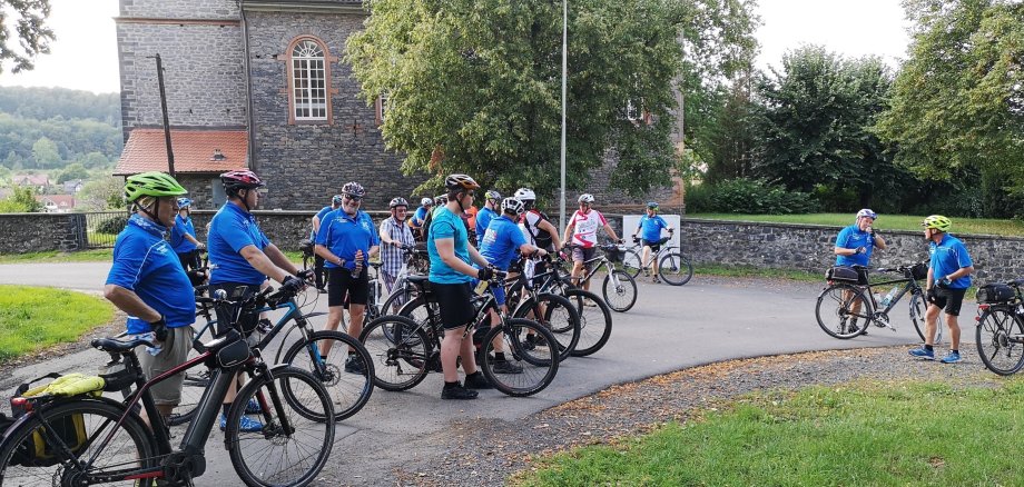 Radler vor der Kirche in Rainrod