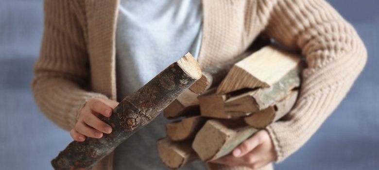 Woman holding pile of firewood, close up view